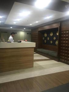 une cuisine avec une personne debout derrière un comptoir dans l'établissement Seaview Amani Grand Resort Residences 3-5mins from airport, à Mactan 14 autres photos