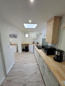 uma cozinha com armários de madeira e uma bancada em Sublime T3 em Saint-Dizier