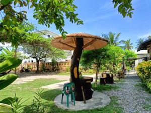 a umbrella on top of a chair under a tree at Allen Marie Shiphaus in Bantayan Island