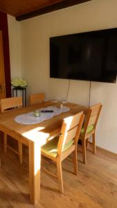 a wooden table with two chairs and a television at Haus Jane in Dornum