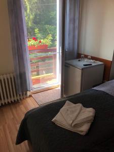 Schlafzimmer mit einem Bett, einem Fenster und einem Waschbecken in der Unterkunft Pensiunea Diskret in Sovata