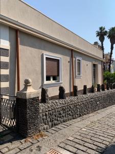 un edificio con una pared de piedra y una ventana en Villa con piscina, en Mascalucia