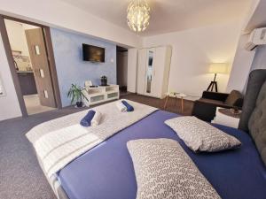 a bedroom with a large bed and a living room at Marcos Apartments - self check-in in Reşiţa