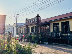 a building with a car parked in front of it at 哈尔滨机场东方红运宾馆 in Harbin