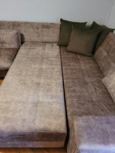 a brown couch with two pillows on it at Rakite Apartment in Kotor