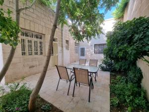 Downtown Living Boutique Apartments في عمّان: فناء مع طاولة وكراسي في ساحة الفناء