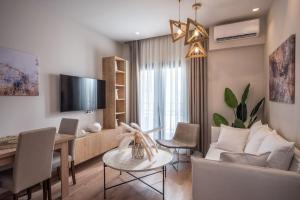 a living room with a couch and a table and chairs at Amalia's Luxury Apartment 1 in Heraklio