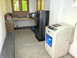a small kitchen with a refrigerator and a sink at Calm Retreat in Mirissa