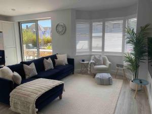 un soggiorno con divano blu e sedia di Hathaway Beach House a Southbourne