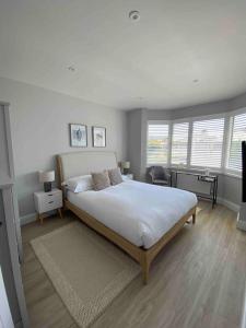 una camera con un grande letto in una stanza con finestre di Hathaway Beach House a Southbourne