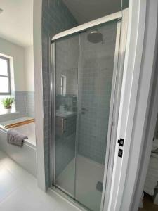 bagno con doccia in vetro e lavandino di Hathaway Beach House a Southbourne
