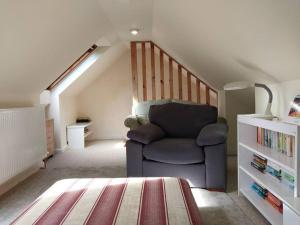 a living room with a chair and a staircase at Idyllic cottage in peaceful rural location in Helensburgh