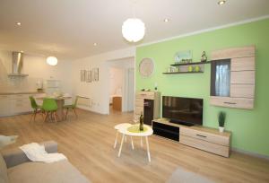 Ferienhaus-Lavanda-2 في بوريتش: غرفة معيشة مع جدران خضراء وغرفة طعام