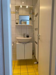 a white bathroom with a sink and a mirror at Ferienwohnung Casa Conti Goslar in Goslar +65 photos
