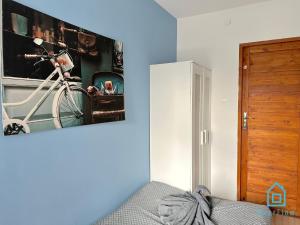 a bedroom with a picture of a bike on the wall at Lama Room in Gdańsk