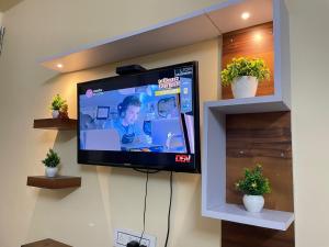 a flat screen tv hanging on a wall at Visit Kashi Stay in Varanasi