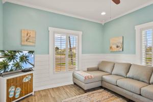 a living room with a couch and a tv at Alister House in Port Aransas