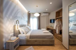 una camera con un grande letto e uno specchio di Amalia's Luxury Apartment 2 a Heraklion