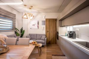 Una cocina y una sala de estar con un sofá y una mesa. en Amalia's Luxury Apartment 2, en Heraclión