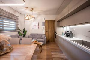 Una sala de estar con un sofá y una cocina. en Amalia's Luxury Apartment 2, en Heraclión