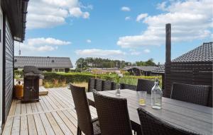 een houten tafel en stoelen op een houten terras bij 3 Bedroom Amazing Home In Rnde in Rønde