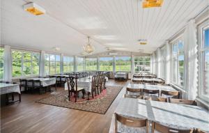 a dining room with tables and chairs and windows at Foldingbro Kro in Lintrup