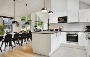 uma cozinha com armários brancos e uma mesa com cadeiras em Aqua 221 em Charlottenthal