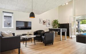uma sala de estar com uma televisão e uma mesa e cadeiras em Aqua 221 em Charlottenthal