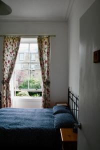 een slaapkamer met 2 bedden en een raam bij Argyle Backpackers in Edinburgh