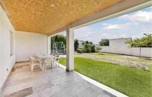 a patio with a table and chairs and a lawn at Stunning Home In Saint-Theodorit in Saint-Théodorit