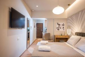 um quarto com uma cama grande e uma televisão de ecrã plano em Amalia's Luxury Apartment 3 em Heraclião