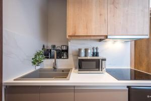 a kitchen with a sink and a microwave at Amalia's Luxury Apartment 3 in Heraklio Town