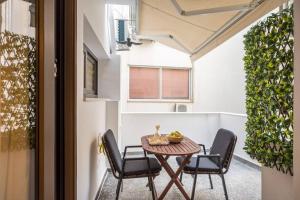 un patio con tavolo, 2 sedie e tavolo di Amalia's Luxury Apartment 3 a Heraklion