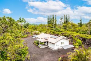 una vista aérea de una casa blanca en el bosque en Keaau Gardens, en Keaau