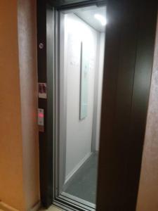 a hallway with a glass door and a mirror at Appart prestigieux+T bien équipé in Fès