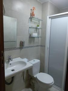 Baño blanco con aseo y lavamanos en Appart prestigieux+T bien équipé, en Fez