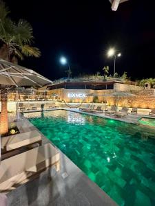 a swimming pool at night with chairs and lights at Bianca Hotel & Villa in Tirana