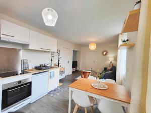 a kitchen and dining room with a table and chairs at 4 en 1- jusqu'à 14 personnes in Riom +11 photos