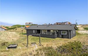 BjerregårdにあるAmazing Home In Hvide Sande With 3 Bedrooms, Sauna And Wifiの丘の上に座る黒家