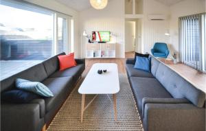 BjerregårdにあるAmazing Home In Hvide Sande With 3 Bedrooms, Sauna And Wifiのリビングルーム(ソファ、テーブル付)