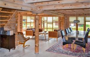 a dining room in a log cabin with a table and chairs at Nice Home In Skjern With Wifi in Lem