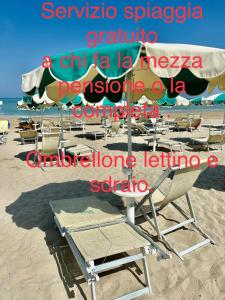 een groep stoelen en parasols op een strand bij Hotel Costa Verde in Pineto