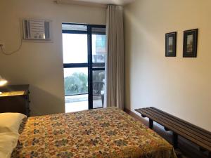 ein Hotelzimmer mit einem Bett und einem Fenster mit Aussicht in der Unterkunft Apto MAR AZUL CARIBE - PRAIA DO FORTE - 3 minutos a pé da praia in Cabo Frio