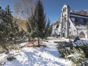 une église blanche avec un arbre de Noël dans la neige dans l'établissement Studio Saint-Lary-Soulan, 1 pièce, 4 personnes - FR-1-296-473, à Saint-Lary-Soulan