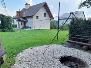 a swing in a yard with a house at Noclegi u Brody in Hoczew