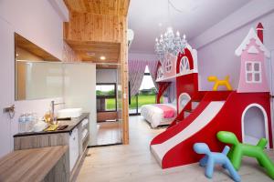 Dormitorio infantil con una estructura de juegos en rojo y blanco en Fairy Story Village Farm B&B, en Dongshan
