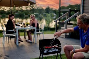 Een man kookt eten op een grill. bij Familie vakantiepark Krieghuusbelten in Raalte