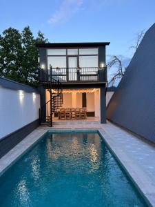 a house with a swimming pool in front of a house at Qafqaz Twin A Frame in Gabala