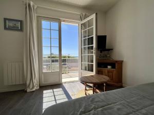 um quarto com uma cama e uma porta de vidro deslizante em Appartement Saint-Pierre-d'Oléron, 4 pièces, 6 personnes - FR-1-246A-269 em Saint-Pierre-dʼOléron
