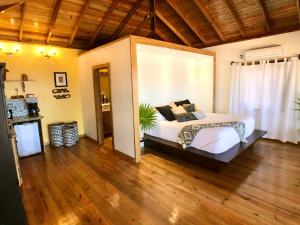 een slaapkamer met een groot bed en een houten vloer bij Turtle Beach Sanctuary, Utila in Utila